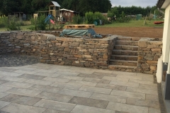 Natursteinmauer mit Terrasse rechts